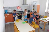 Bild: Aus dem Kita-Alltag: In der eigenen K&uuml;che macht die Zubereitung von Speisen und das Saubermachen noch mehr Spa&szlig;. 
