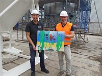 Bild: Projektteilnehner mit ihren Entw&uuml;rfen vor den einger&uuml;steten Silos