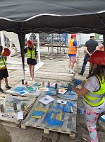 Bild: Projektteilnehner mit ihren Entw&uuml;rfen vor den einger&uuml;steten Silos