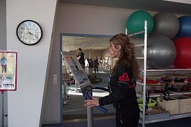 Bild: Kristin Goepp-Erny f&uuml;hrt ein neues Trainingsger&auml;t vor. Im Hintergrund der Fitness-Raum, der ebenfalls neue Sportger&auml;te erh&auml;lt. 