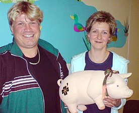 Bild: Madeleine Gogsch &uuml;bergibt das Sparschwein an Tino Meyer