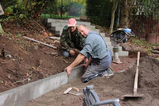 &ouml;rg Blank und Helmut Riechel (rechts) von der Firma GAI aus Niedersachswerfen beim Einsetzen der Borde f&uuml;r die neue Treppenanlage an der K&auml;the-Kollwitz-Schule. (Foto: Ilona Bergmann)