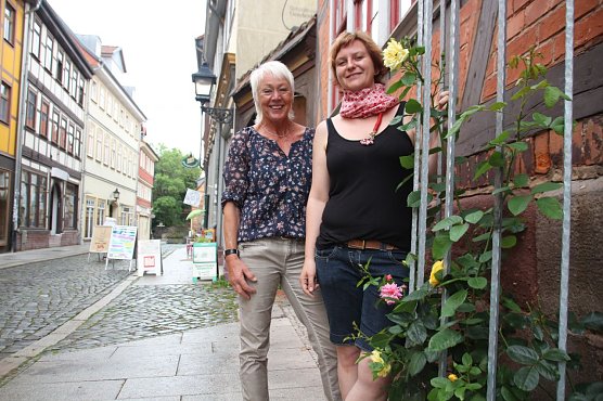 Ruth Hagene und Stephanie Tiepelmann-Halm (v.l.n.r.) danken und  freuen sich, dass die im vorigen November gepflanzten Rosen von der Kreativen Altstadtgruppe nun zum ersten Mal bl&uuml;hen (Foto: Ilona Bergmann, Pressestelle Stadt Nordhausen)