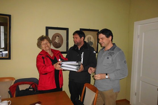 Stefan Petrat, Halle &uuml;bergibt die umfangreiche Dokumentation  nach der umfassenden Sanierung der Haupttreppe, der Stra&szlig;e und der Trockenmauer unter der Verlobungsbr&uuml;cke an Gisela Hartmann, Vorsitzende der B&uuml;rgerstiftung und Sven Liss vom Vorstand des F&ouml;rdervereins und Vorsitzender des Baustammtisches (Foto: Gisela Hartmann)