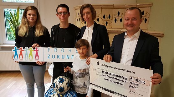 Thomas Mund &uuml;bergibt an Jeannine Lindner vom Kinder- und Jugendheim Frohe Zukunft einen Spendenscheck in H&ouml;he von 350,00 Euro sowie ein Netz voller Fu&szlig;b&auml;lle in verschiedenen Gr&ouml;&szlig;en (Foto: Marco Bachmann, Stadtwerke Nordhausen)
