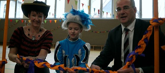 Schulleiterin Sabine Wagner, eine Sch&uuml;lerin und Landrat Matthias Jendricke durchschneiden symbolisch das Band (Foto: nnz)
