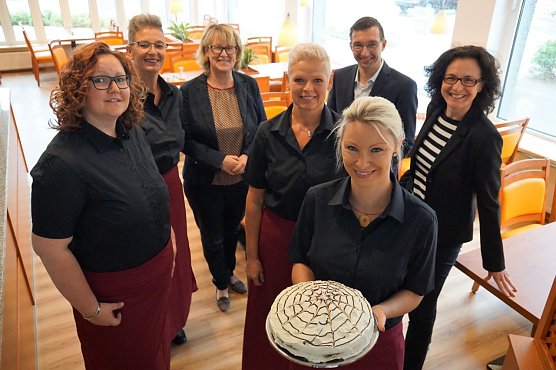 Das Caf&eacute;hausteam um Karin Rabe, Katrin Kaufhold, Jana Schr&ouml;dter und Madeleine Kuhfahl erwarten am Dienstag die ersten G&auml;ste im Mittendrin (v.l.n.r. in roten Sch&uuml;rzen). SWG-Chefin Inge Klaan und Seniorenwerkgesch&auml;ftsf&uuml;hrer Christian D&ouml;ring sowie seine Assistentin Sandra Hoche (v.l.n.r. hinten) freuen sich, dass das Caf&eacute; jetzt bald &ouml;ffnet (Foto: SWG Nordhausen)