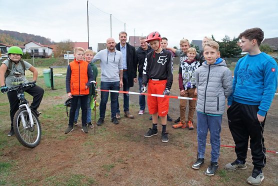Leander Koch durchschneidet symbolisch f&uuml;r alle jungen Helfer das Band. Am Donnerstag wurde der Hometrail auf dem Sportplatz in Niedersachswerfen er&ouml;ffnet (Foto: Gemeinde Harztor/Susanne Schedwill)