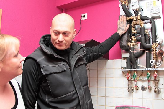 Andr&eacute; Schlesier von der Nordh&auml;user Firma Rilka erl&auml;utert Mieterin Julia Sch&ouml;nemann wie die Fernw&auml;rmestation arbeitet und wo sie den Verbrauch ablesen kann. (Foto: Susanne Schedwill/SWG Nordhausen)