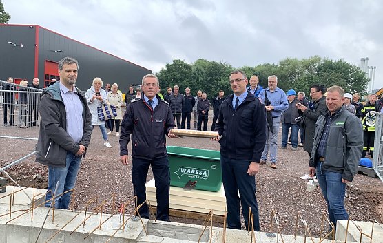 Den Kameraden der Feuerwehr war es vorbehalten, die Zeitkapsel in den Baugrund zu versenken (Foto: oas)