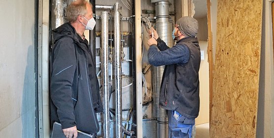 Elektriker Norman Fischer (rechts) und Karsten Gr&uuml;neberg von der SWG begutachten in einer Wohnung in der Dr.-Robert-Koch-Stra&szlig;e in Nordhausen die neu eingezogenen Versorgungsleitungen in einem Schacht. (Foto: SWG Nordhausen/Susanne Schedwill)