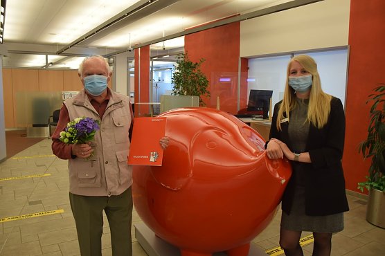 Kundenberaterin Lena Seidenst&uuml;cker &uuml;berreicht dem gl&uuml;cklichen Gewinner die Gewinnunterlagen f&uuml;r das Auto. (Foto: Kreissparkasse Nordhausen)