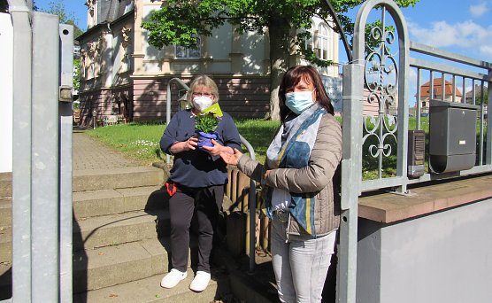 Cornelia M&ouml;nnich (rechts) vom Familienzentrum freut sich &uuml;ber die gute Nachbarschaft und &uuml;bergibt einen Blumengru&szlig;. (Foto: Familienzentrum)