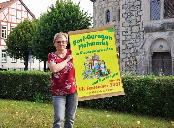Gabriele Neumeyer zeigt eines der Plakate, mit denen in der kommenden Woche auf den Garagenflohmarkt in Niedersachswerfen und Harzungen aufmerksam gemacht werden soll. (Foto: Susanne Schedwill)