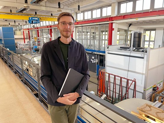 Dr. Pascal Leibbrandt mit seiner Doktorarbeit (Foto: Tina Bergknapp)