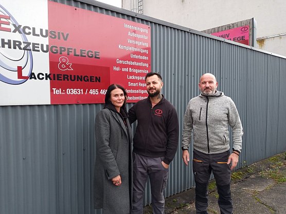 Theresa Stobbe, Buchhalterin bei CAR DESIGN, Shamsul Ahmadi und Filialleiter Axel Kaiser vor dem Firmenlogo. (Foto: Kurt Frank)