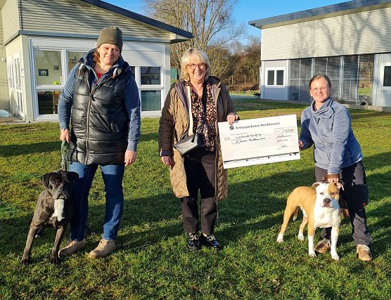 SWG-Chefin Inge Klaan &uuml;bergab den symbolischen Spendenscheck an Gesch&auml;ftsstellenleiterin Sandra M&uuml;hle (links mit Zara) und Tierheim-Chefin Jennifer Schenk (rechts mit Donny). (Foto: SWG Nordhausen/S.Schedwill)