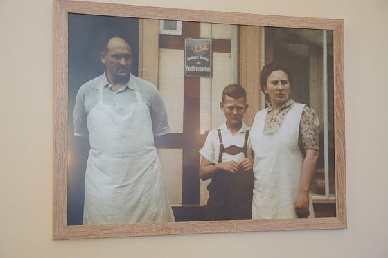 Bild: Rolf Hoppe als Heranwachsender zwischen seinen Eltern vor der B&auml;ckerei.  