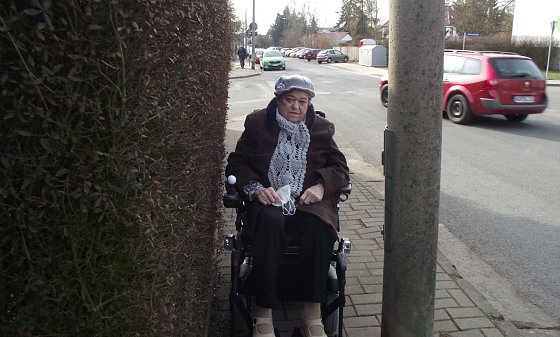 Bild: W&auml;re der Rollstuhl etwas breiter, bliebe die Seniorin zwischen Zaun und Masten eingeklemmt.