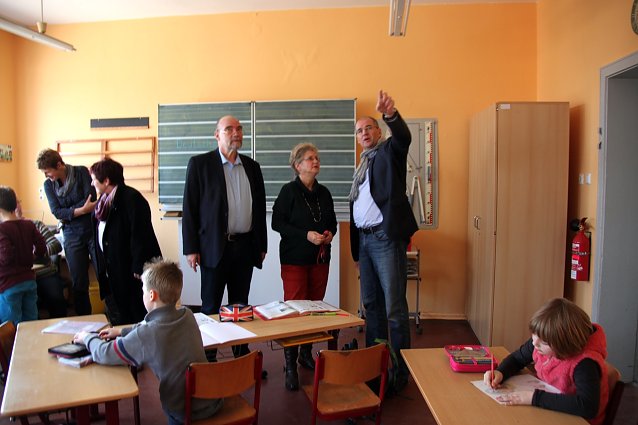 Bild: Uta Morgenstern, Schulsozialarbeiterin Annika Lier (Frohe Zukunft e.V.), B&uuml;rgermeister Wolfgang Morgenstern, Schulleiter Helmut Herntrich, Matthias Jendricke, Hans-Georg M&uuml;ller (Schulverwaltungsleiter) Stellvertretende Schulleiterin Borjana Venth vor einer Sch&uuml;lerarbeit