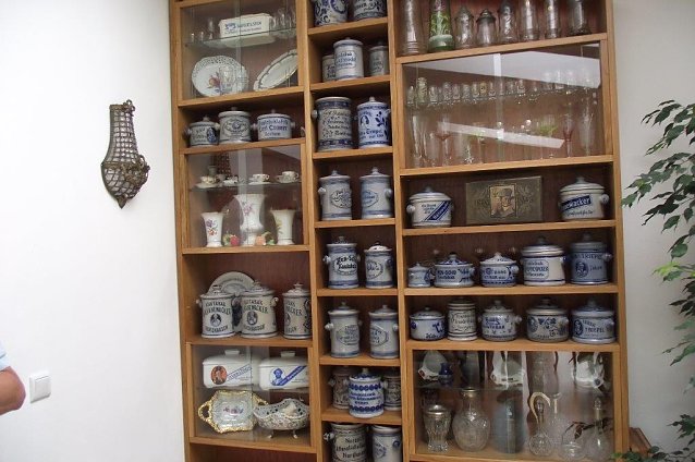 Bild: Eine Vitrine voller Kautabakt&ouml;pfe. Auch Werbe-Schnapsgl&auml;ser einstiger Firmen finden sich.