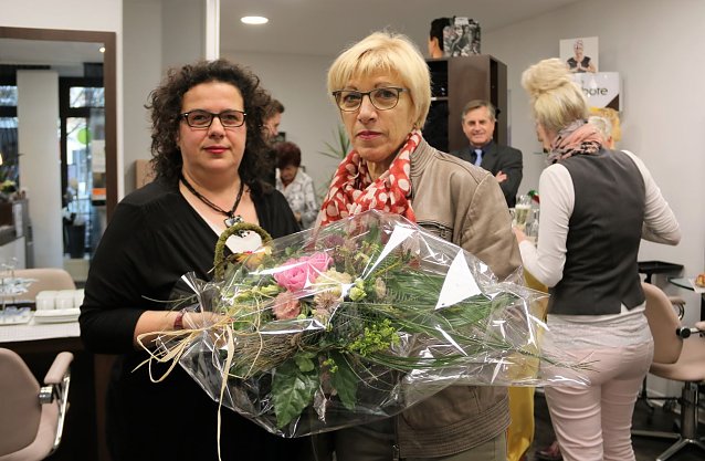 Bild: Anett Vollborth erh&auml;lt von Renate Gruben einen Blumenstrau&szlig; zur Begr&uuml;&szlig;ung in den neuen Salonr&auml;umen