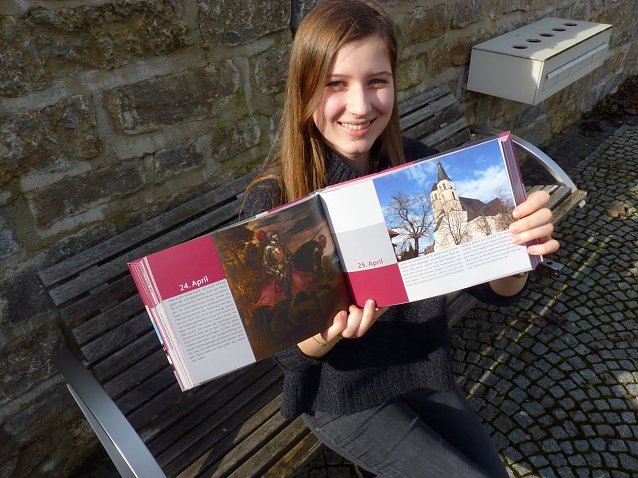 Bild:  Die Kulturfreiwillige Henriette Eisfeld pr&auml;sentiert den Jahresbegleiter zum Reformationsjubil&auml;um. Aufgeschlagen ist der Beitrag zu Nordhausen. 