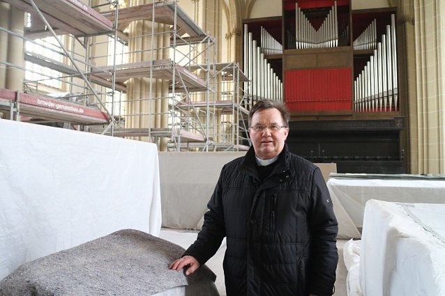 Bild: Pfarrer Richard Hentrich vor der gro&szlig;en Orgel
