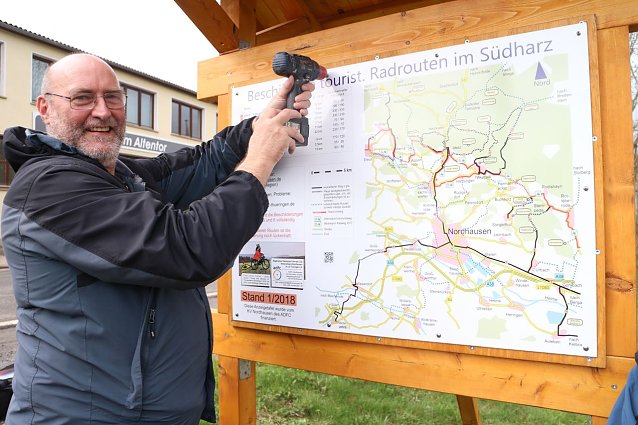 Bild: Der Vorsitzende des Nordh&auml;user ADFC Kar-Heinz Gr&ouml;pler bringt die letzte Schraube an der neuen Tafel an