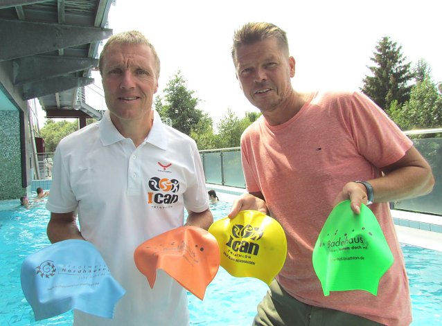 Bild: Renndirektor des ICAN Nordhausen, Ulrich Konschak, und Gesch&auml;ftsf&uuml;hrer der Badehaus Nordhausen GmbH, Jens Eisenschmidt, pr&auml;sentierten auch in diesem Jahr wieder die neu gestalteten Badekappen f&uuml;r die Athleten des Scheunenhof- und ICAN-Triathlons am kommenden Wochenende.