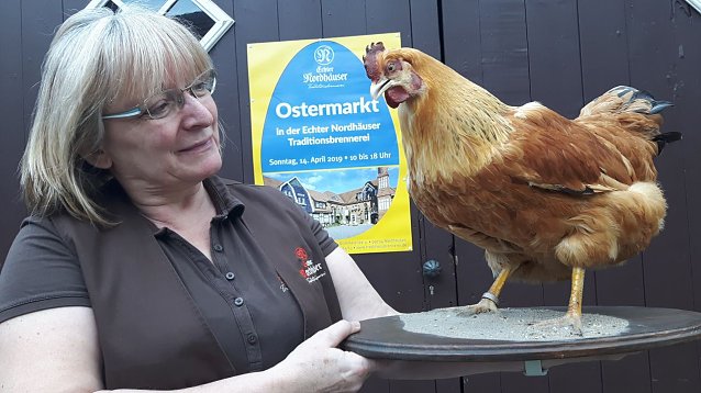 Bild: Roswitha Prescher bereitet mit ihren Kolleginnen der Echter Nordh&auml;user Traditionsbrennerei den ersten Ostermarkt vor. Huhn Henriette ist immer dabei.