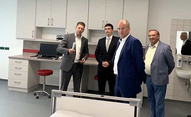 Bild: Guido Hage (l.) und sein neuer &Auml;rztlicher Leiter der Notfallaufnahme, Julian Gonschorrek (2.v.l.), erl&auml;utern Landrat Matthias Jendricke die technischen M&ouml;glichkeiten