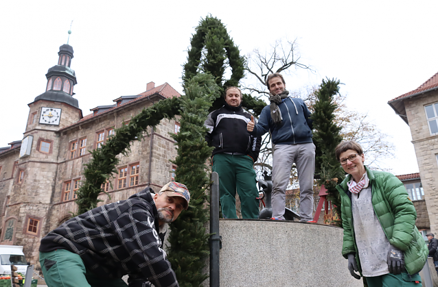Bild: Die Mitarbeiter des VHS Bildungswerks Gerald Becker, Sven Meinicke und Torsten Keitz mit Ausbilderin Petra Bender beim Schm&uuml;cken des Aar-Brunnens vor dem Rathaus