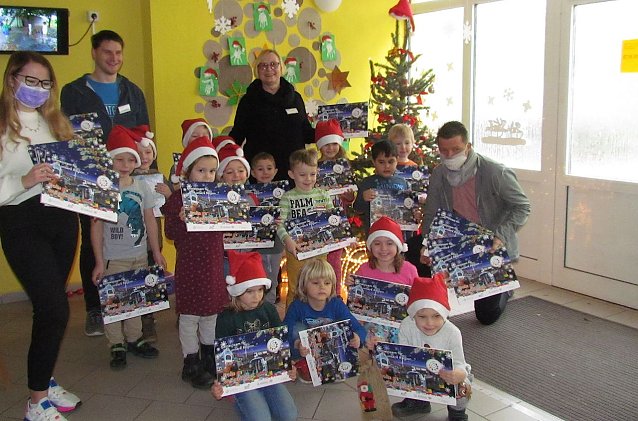 Bild: Jens Eisenschmidt &uuml;bergibt mit der Auszubildenden Michelle Ropte die ersten der 237 Kalender an die Kinder von Steffi Weber