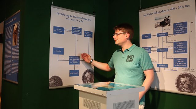 Bild: Alexander Hahn f&uuml;hrt durch die M&uuml;nz-Ausstellung