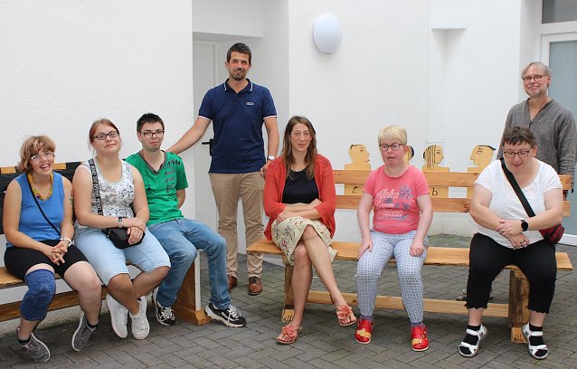 Bild: Foto: Lebenshilfe-Mitarbeiter Torsten Rieschel (4.v.l.), Praktikantin Laura Johann (5.v.l.) und Kursleiter Martin Jahn (rechts im Bild) freuen sich, die B&auml;nke an Projektteilnehmern und Hausbewohnern &uuml;bergeben zu d&uuml;rfen. Nicht alle B&auml;nkebauer waren zum Fototermin anwesend.