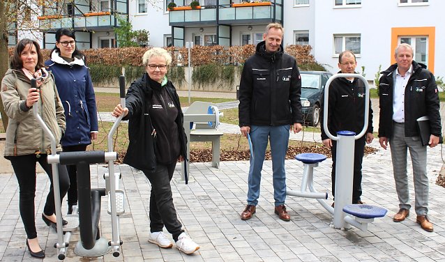 Bild: Sabrina Richter, Saskia Thomas, Objektmanagerin Sabine Hardrath, Sven D&ouml;rmann, Mario Vopel und Steffen Loup (v.l.n.r.) an den Seniorenfitness-Ger&auml;ten im Innenhof des Aueblicks