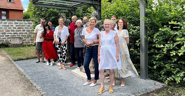 Bild: Leicht verdeckt von den vielen Bef&ouml;rderern die beiden Figuren im Hintergrund: Vor den Brunnenfiguren in der Flohburg: Thomas Kopf, Pia Wienrich, Jessica S. M&uuml;ller, B&uuml;rgermeisterin Alexandra Rieger, Frank Lawrenz, Heidelore Kneffel, Hans-J&uuml;rgen Gr&ouml;nke, Dr. Cornelia Klisch, Evelin Herzberg, Josefa Presslmaier, Mike Szybalski, Simone Hannemann