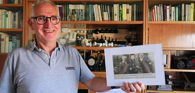 Thomas Liebram mit einem alten Zeitungsausschnitt, er zeigt seinen Vater Heinz Liebram und seinen Gro&szlig;vater Fitz Hilpert in der Werkstatt. Foto: ssc