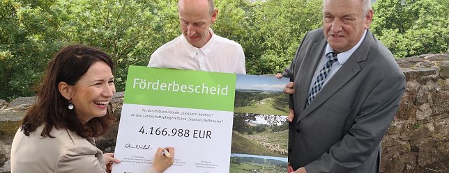 Bild: Ministerin Siegesmund unterschreibt den Bescheid, rechts der Chef des Landschaftspflegeverbandes, Egon Primas