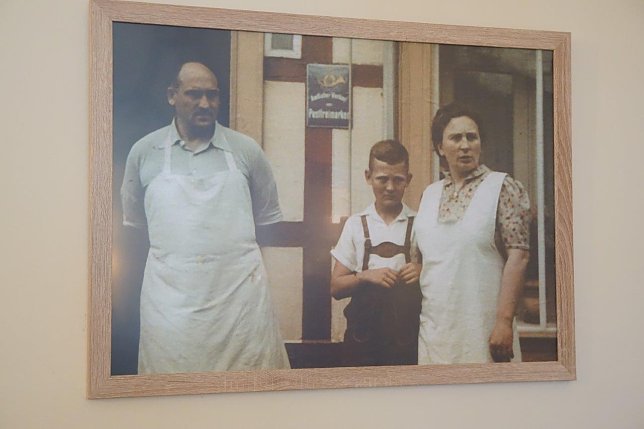 Bild: Rolf Hoppe als Heranwachsender zwischen seinen Eltern vor der B&auml;ckerei.  