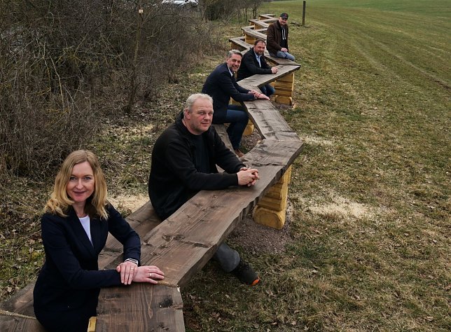Bild: Kultur- und Tourismusausschussvorsitzende Jeanette Goedecke, Harztorb&uuml;rgermeister Stephan Klante, Mario Eckhardt, Formula-Chef Elmar Zimmer und Landwirt Steffen Peix an der 30,5 Meter langen Sitzbank zwischen Harzungen und Niedersachswerfen.
