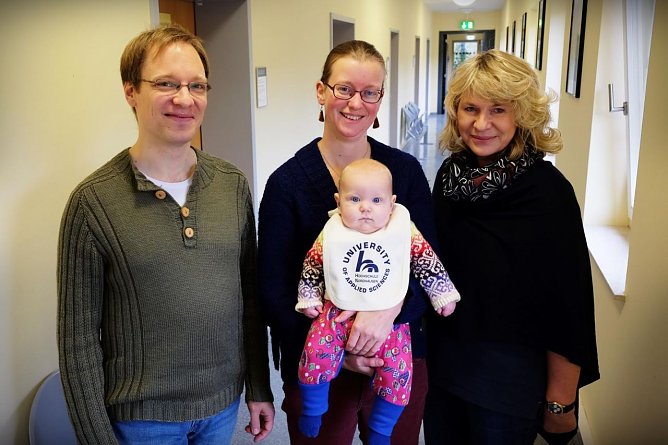 Lotte freut sich &uuml;ber ihr Hochschul-L&auml;tzchen � und mit ihr Papa Tobias, Mama Hanneke sowie Prof. Dr. Sabine Seibold-Freund (Foto: Tina Bergknapp)