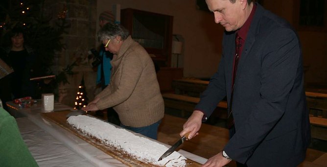 B&uuml;rgermeister Matthias Ehrhold und Pfarrerin Hilde J&uuml;ngling beim Stollenanschnitt. (Foto: S. Schedwill)