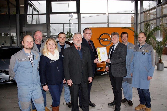 Carsten Klein, Regionalleiter Service, &uuml;bergibt den Pokal im Beisein von Kundendienst-Gebietsleiter Enrico M&uuml;ller und dem Nordh&auml;user Opel-Service-Team an Centerleiter Achit T&ouml;lle (Foto: Fischer/AHP)