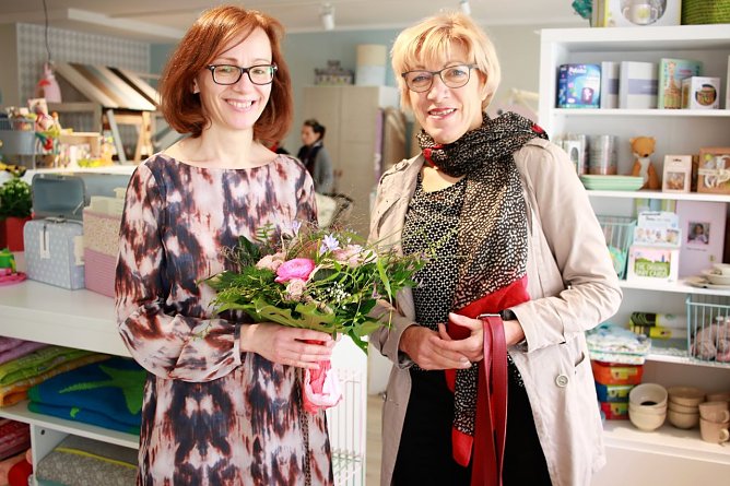 Sabine Becker erh&auml;lt von Renate Gruben zur Neuer&ouml;ffnung ihres Kinderladens Luna Blumen. (Foto: SWG)