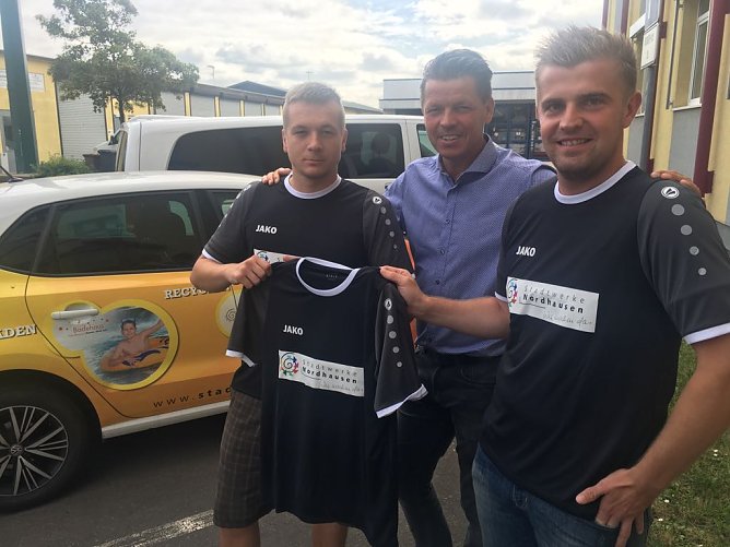 Jens Eisenschmidt von den Stadtwerken Nordhausen, &uuml;bergab T-Shirts mit Unternehmenslogo an die Mitarbeiter Torsten Sch&ouml;nleiter und Martin Hohl (Foto: Marco Bachmann, Stadtwerke Nordhausen)