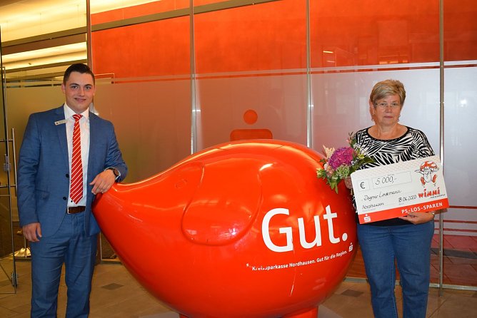 Kundenberater Maximilian Heine (Filiale Kornmarkt) &uuml;berreicht der gl&uuml;cklichen Gewinnerin einen symbolischen Scheck (Foto: Kreissparkasse Nordhausen)