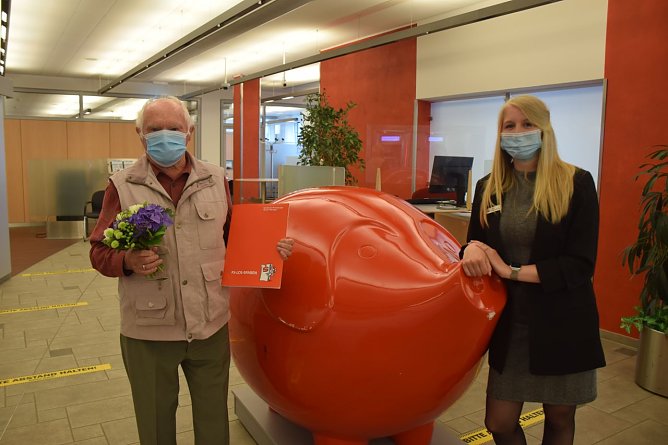 Kundenberaterin Lena Seidenst&uuml;cker &uuml;berreicht dem gl&uuml;cklichen Gewinner die Gewinnunterlagen f&uuml;r das Auto. (Foto: Kreissparkasse Nordhausen)