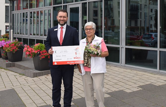 Kundenberater Daniel Czerwinski &uuml;berreicht der gl&uuml;cklichen Gewinnerin den symbolischen Scheck. (Foto: KSK)